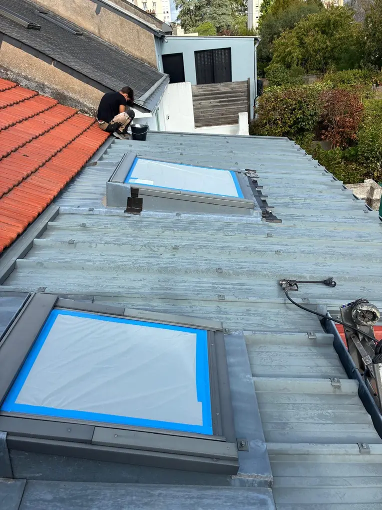 Fenêtres de toit protégées pendant un chantier de couverture en zinc